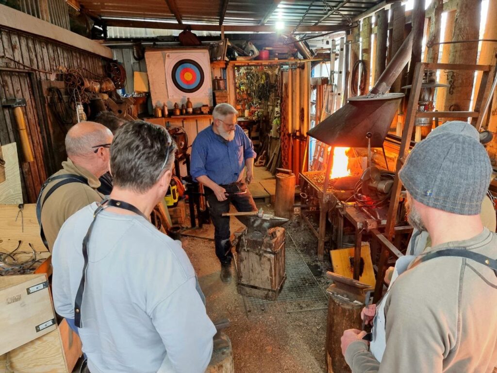 Teamarbeit in der Schmiede — Gruppe beim Teamevent